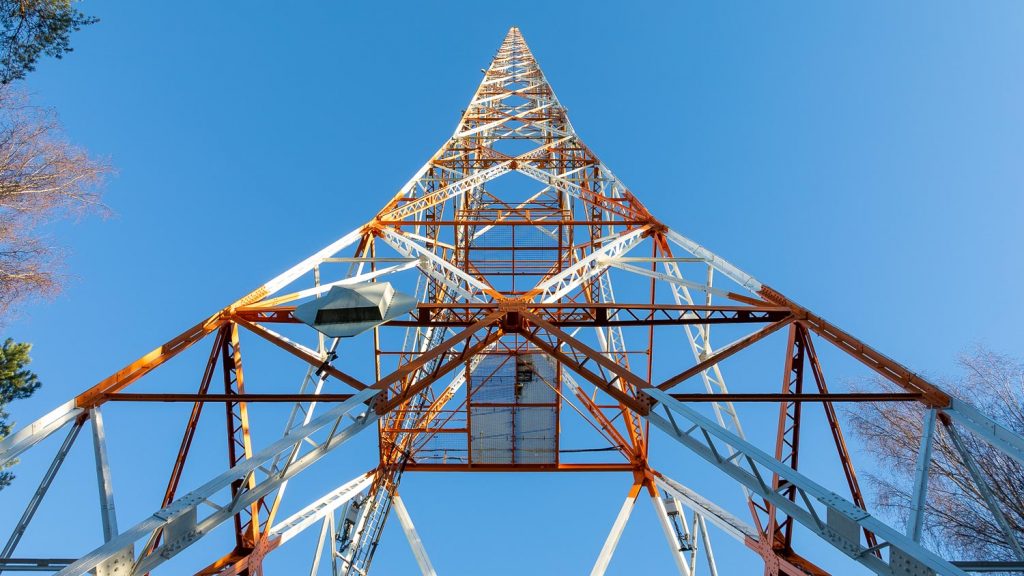 Radiomasto kuvattuna maston juurelta ylöspäin. Radiomaston väritys koostuu valkoisesta ja oransista.