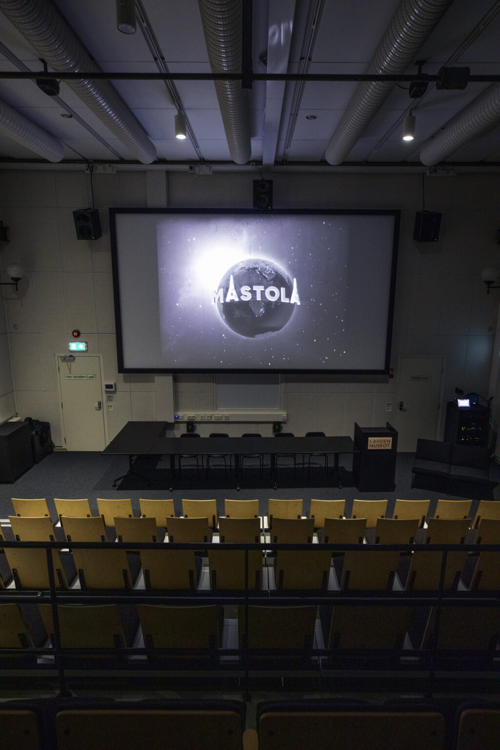 Pystykuva Mastolan uudistetusta auditoriosta. Auditoriossa päivitettiin esitystekniikan lisäksi yleisöistuimet ja esiintyjien kalusteet.