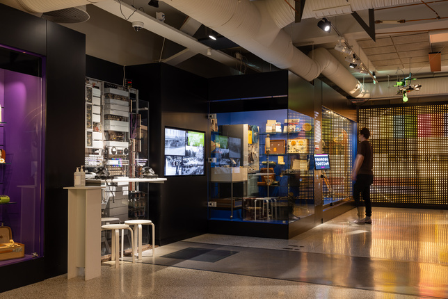 Yleiskuva Kuulemiin ja näkemiin- näyttelystä. Henkilö seisoo vitriinin edessä.